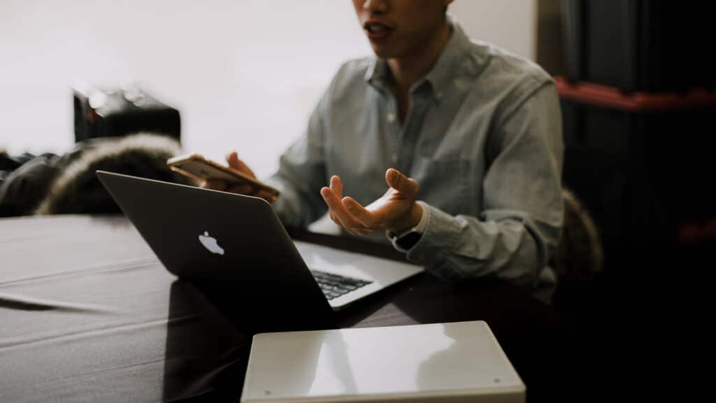 man sitting in front of computer talking