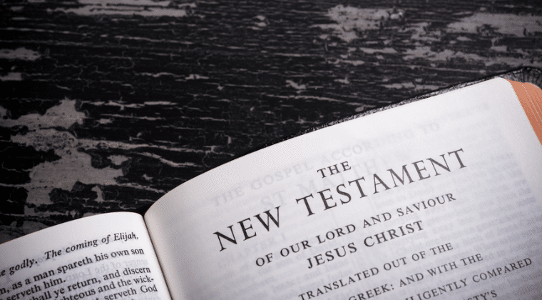 Bible open to New Testament on a black table